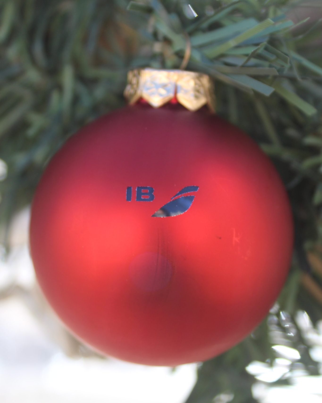 Shiny red Christmas tree bauble branded with the livery of Iberia