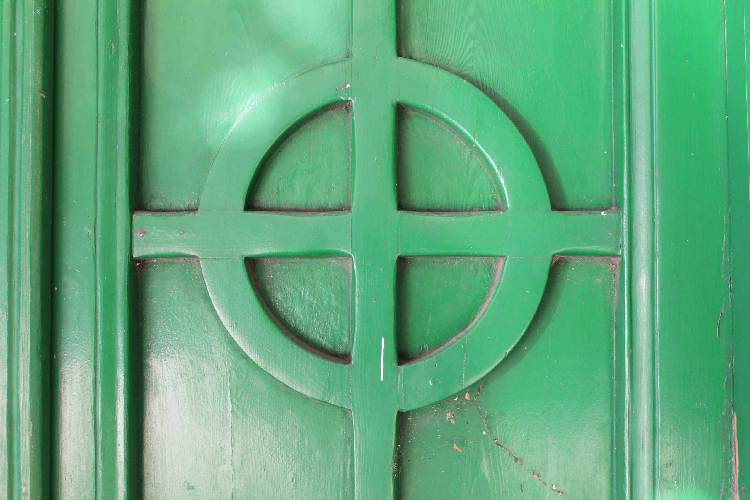 Green painted door in Melilla featuring a design of a Celtic Cross