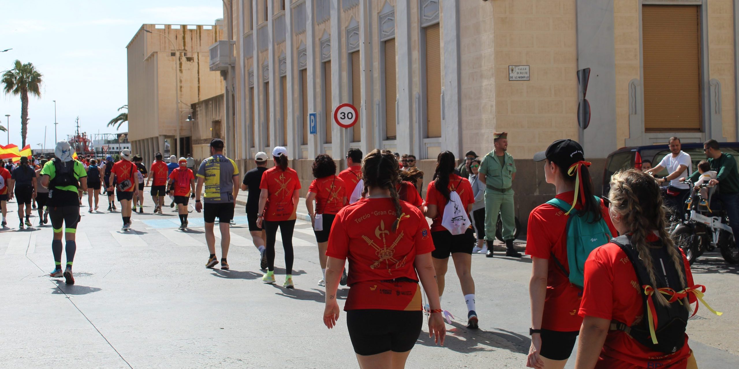 Crowd of Melillan people in orange t-shirts walking through the streets of Melilla