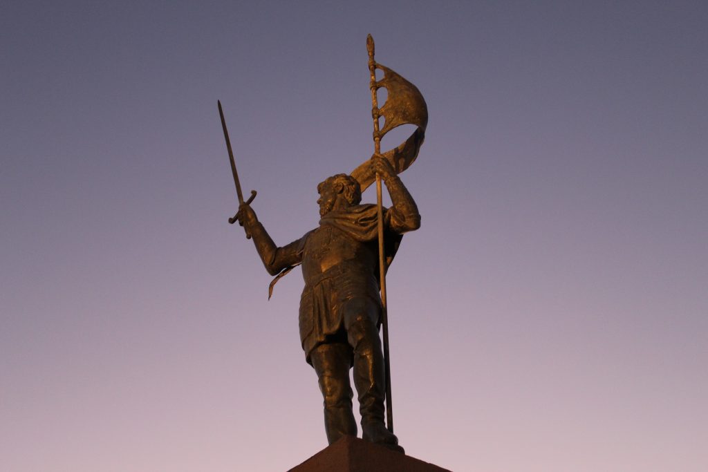 Towering sculpture of Melilla's liberator, Pedro de Estopinan, backlit in pinkish-grey dusk hues at Melilla la Vieja
