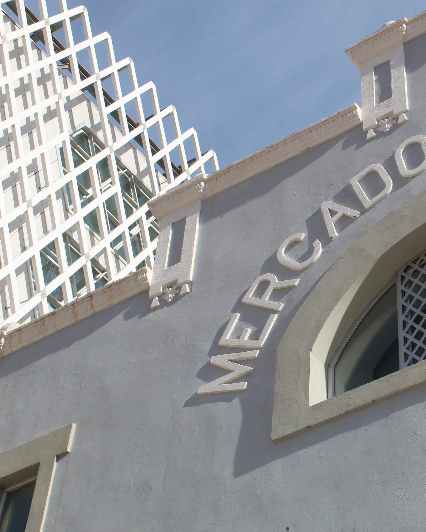 Melilla's historic grey-coloured Mercado Publico building backed by modern building with crosshatch design