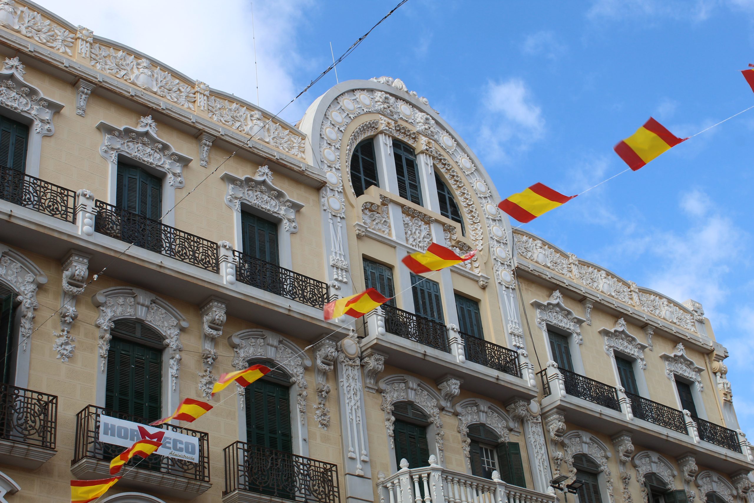 Ornate Spanish building in a street decorated with nationalistic Spanish bunting