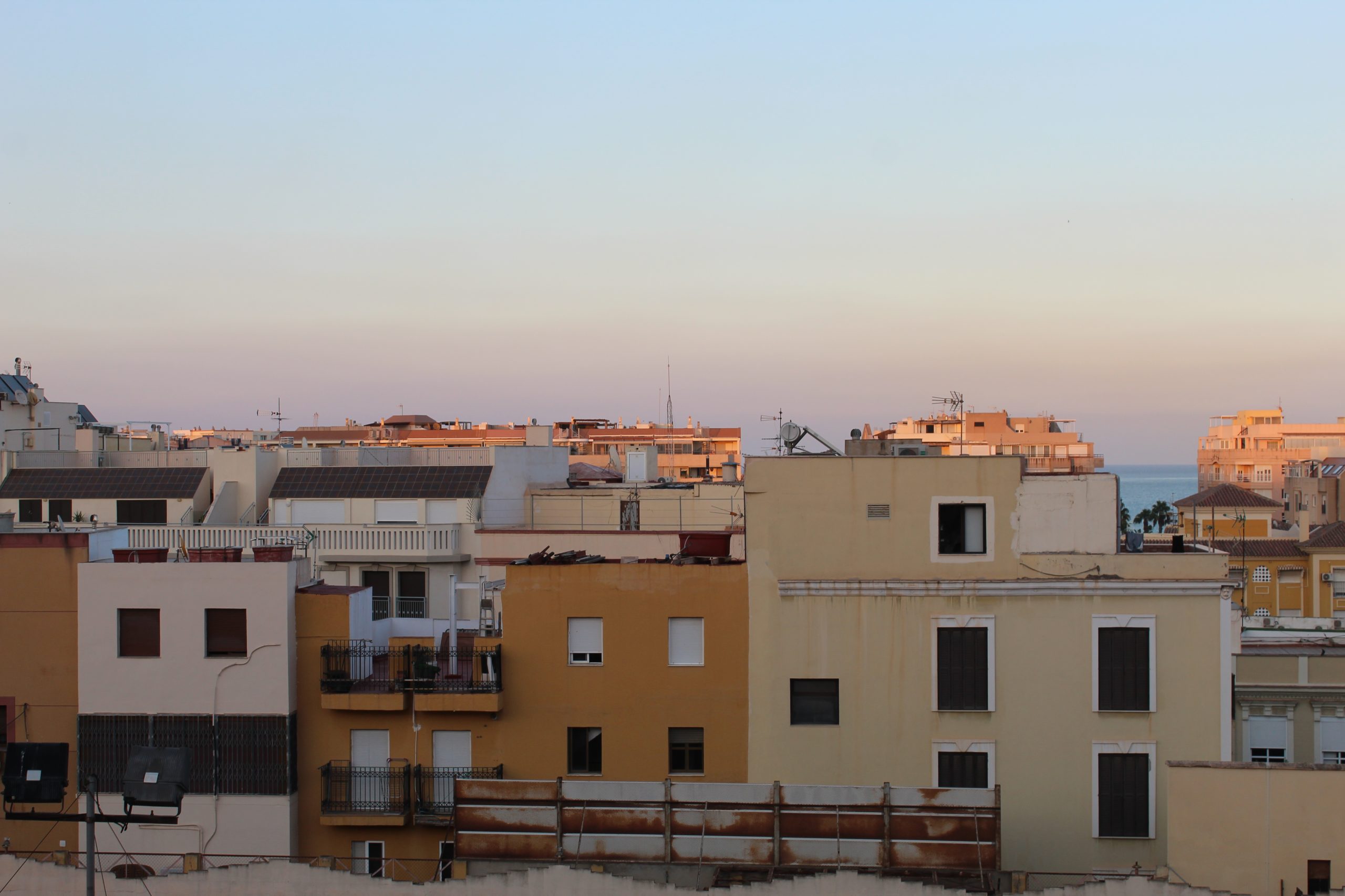 Skyline of Spanish apartment buildings in the warm glow of sunset over the Mediterranean in Melilla