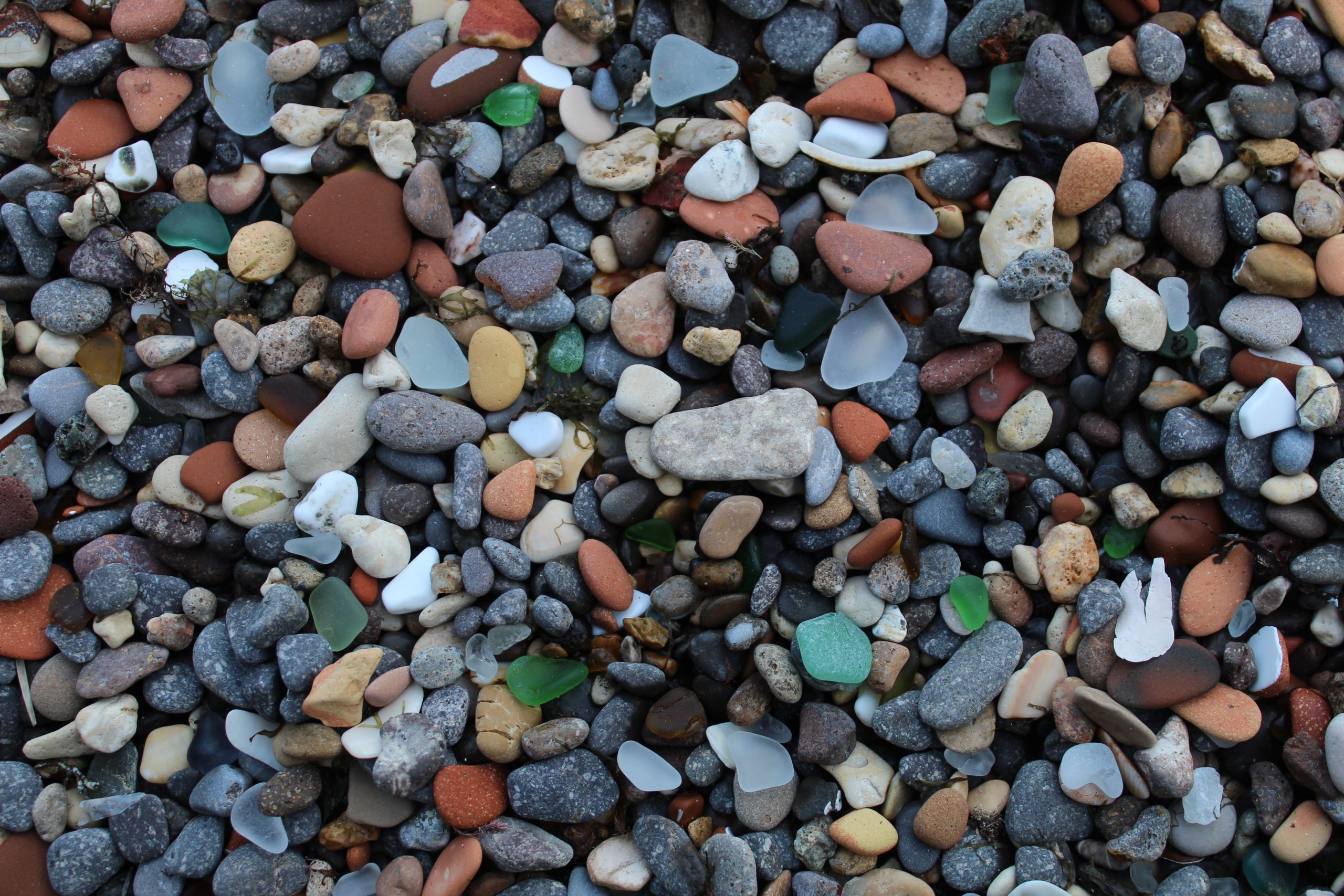 Assorted colours of pebbles and sea glass on a Spanish beach