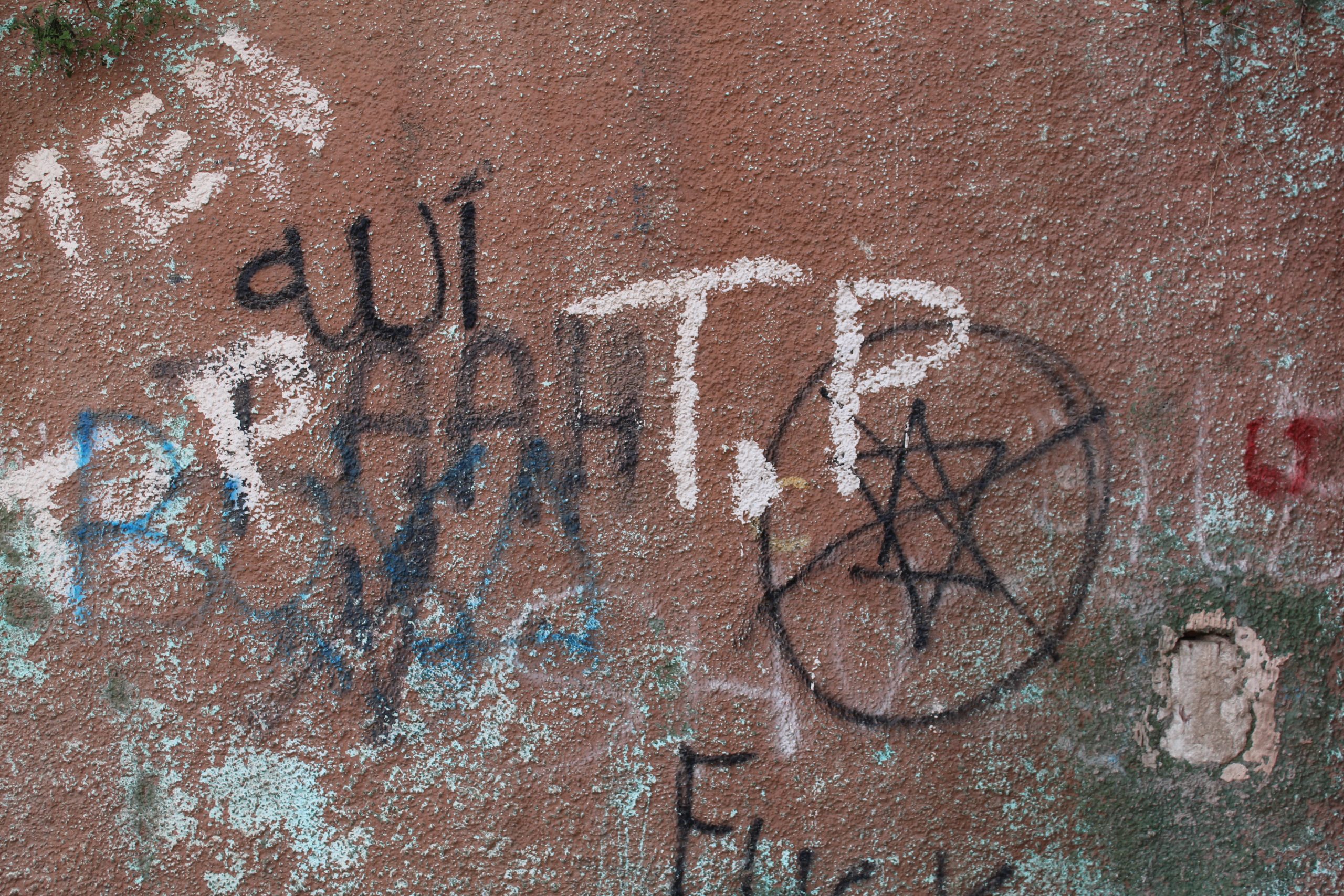 Wall with graffiti in Arabic and a defaced Star of David
